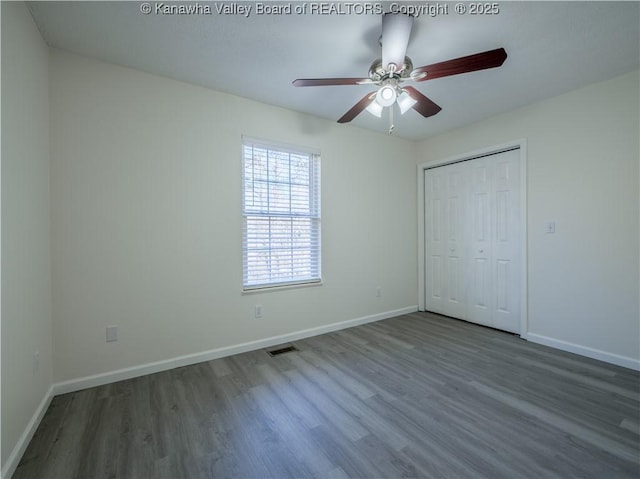 unfurnished bedroom featuring a closet, ceiling fan, and dark hardwood / wood-style flooring