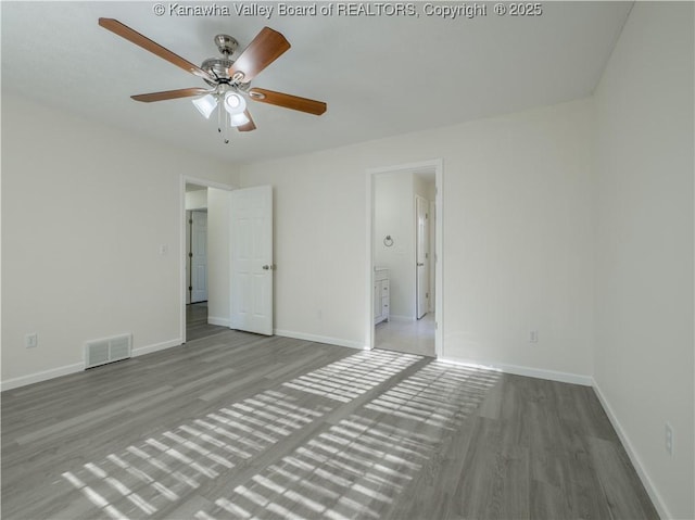 unfurnished bedroom with ensuite bath, light wood-type flooring, and ceiling fan