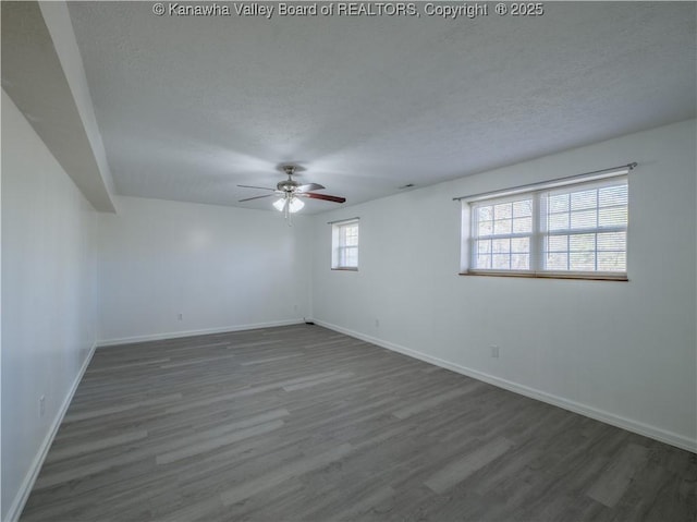 empty room featuring a textured ceiling, ceiling fan, and dark hardwood / wood-style floors