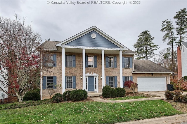 greek revival house featuring a front yard and a garage