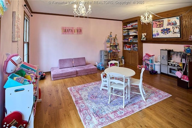 game room featuring a notable chandelier, crown molding, and hardwood / wood-style flooring