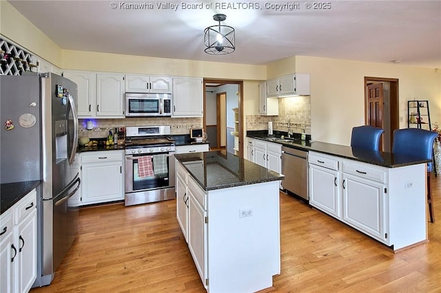 kitchen featuring stainless steel appliances, a kitchen island, and white cabinetry