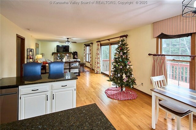 kitchen featuring white cabinets, ceiling fan, dark stone counters, and light hardwood / wood-style flooring