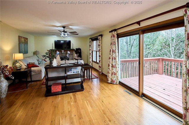 living room featuring ceiling fan and light hardwood / wood-style flooring