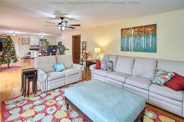 living room with ceiling fan and light hardwood / wood-style floors