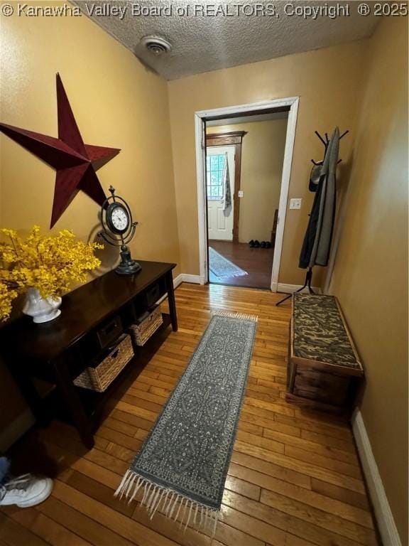 hallway with wood-type flooring and a textured ceiling