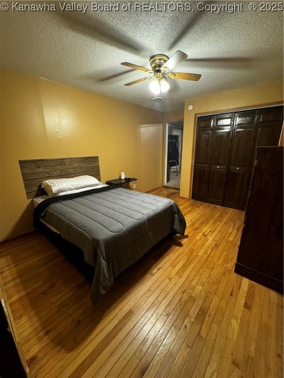 bedroom featuring a textured ceiling, ceiling fan, and light hardwood / wood-style floors