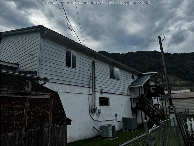 view of side of home with central AC