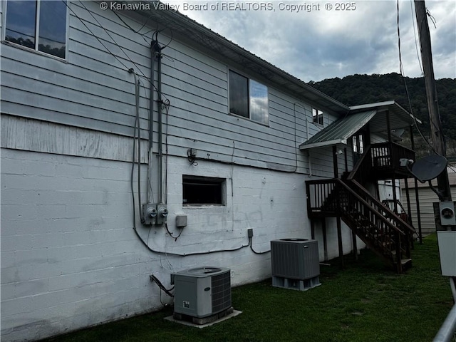 view of home's exterior with a yard and central AC