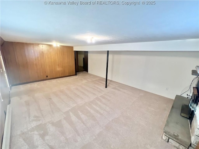 basement featuring wooden walls and light carpet