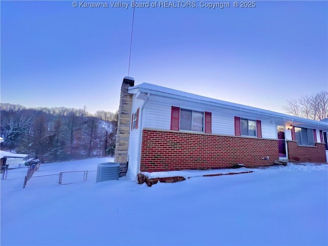 view of snow covered exterior with central AC