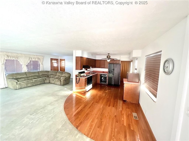 living room with ceiling fan, beverage cooler, and wood-type flooring