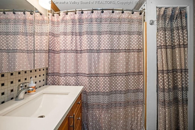 bathroom with a shower with shower curtain, vanity, and backsplash