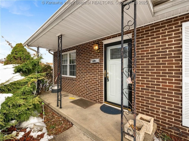 view of exterior entry featuring covered porch