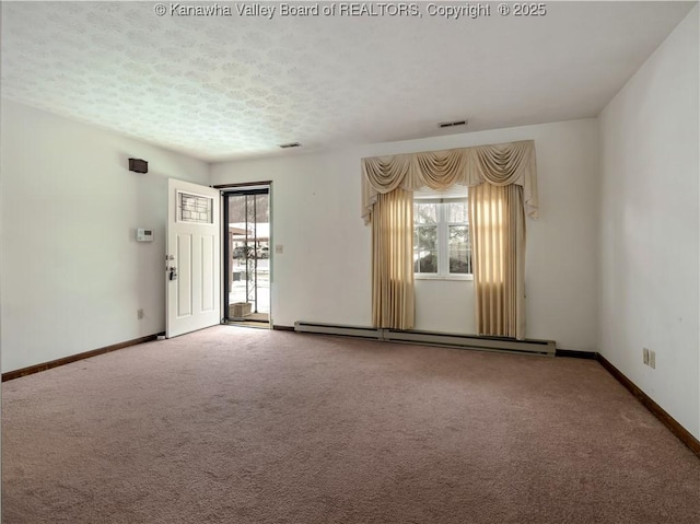 carpeted empty room featuring baseboard heating, a textured ceiling, and a wealth of natural light