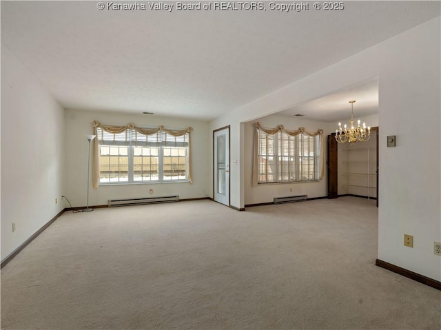 spare room featuring a baseboard radiator, light carpet, and a notable chandelier