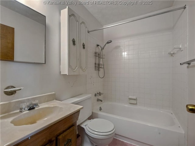 full bathroom featuring vanity, tiled shower / bath combo, and toilet