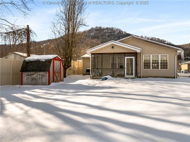 snow covered property with a storage shed