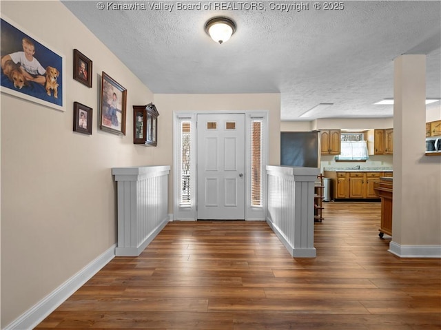 entrance foyer with dark hardwood / wood-style floors and a textured ceiling