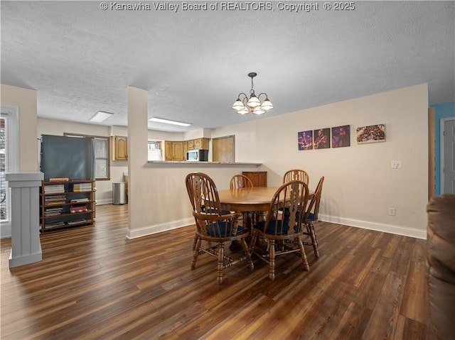 dining space with dark wood-type flooring and an inviting chandelier