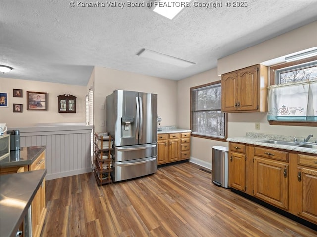 kitchen featuring sink, a textured ceiling, stainless steel fridge with ice dispenser, and a wealth of natural light