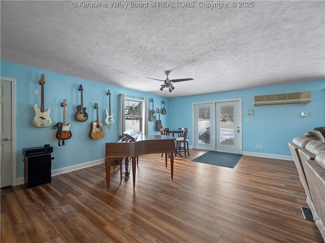 office space featuring ceiling fan, a textured ceiling, dark hardwood / wood-style floors, and a wall mounted air conditioner