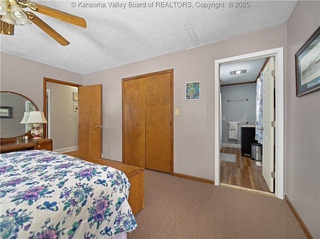 bedroom with ceiling fan, light colored carpet, ensuite bathroom, a textured ceiling, and a closet