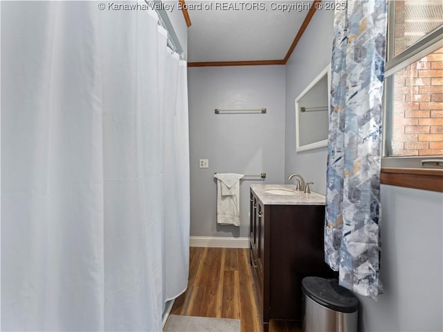 bathroom with hardwood / wood-style flooring, vanity, and crown molding