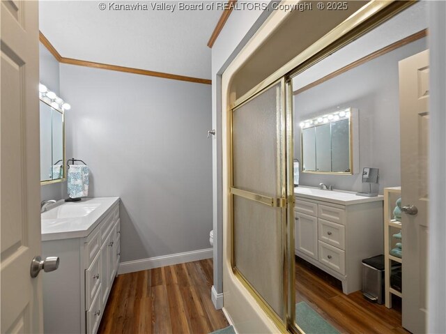 full bathroom with toilet, bath / shower combo with glass door, vanity, wood-type flooring, and ornamental molding