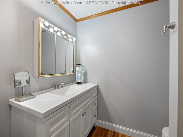 bathroom with toilet, ornamental molding, hardwood / wood-style floors, and vanity