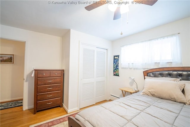 bedroom featuring a closet, multiple windows, light hardwood / wood-style flooring, and ceiling fan