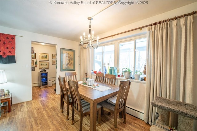 dining area featuring a baseboard heating unit, hardwood / wood-style floors, and a notable chandelier