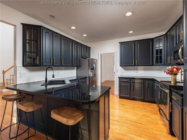 kitchen with sink, kitchen peninsula, stainless steel appliances, and a breakfast bar area