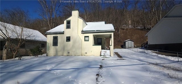 view of snow covered back of property