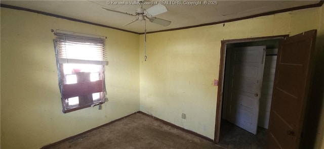 unfurnished room featuring ceiling fan, ornamental molding, and dark colored carpet