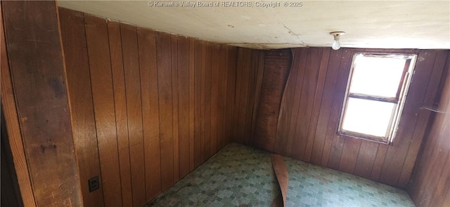 unfurnished room featuring wood walls