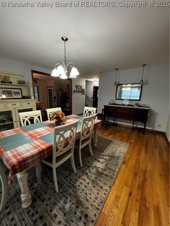 dining area with hardwood / wood-style floors and a notable chandelier