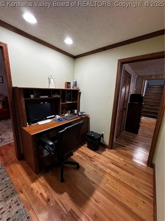 home office featuring ornamental molding, a textured ceiling, and light hardwood / wood-style flooring