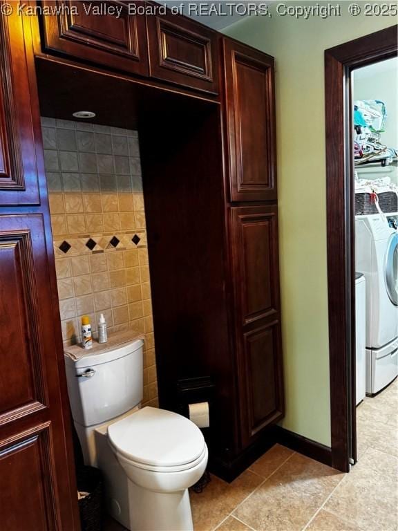 bathroom with toilet, washer and dryer, and tile patterned floors