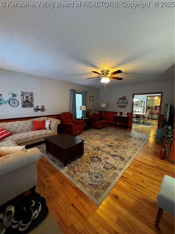 living room with ceiling fan and hardwood / wood-style floors