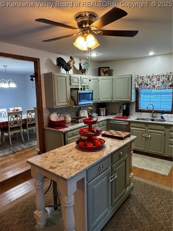 kitchen with sink, stainless steel appliances, a kitchen island, and tasteful backsplash