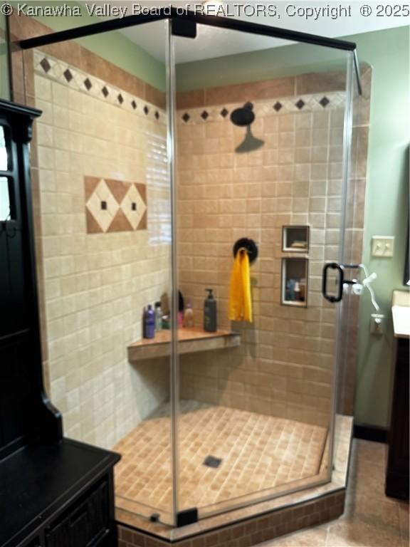 bathroom featuring a shower with shower door, tile patterned floors, and vanity