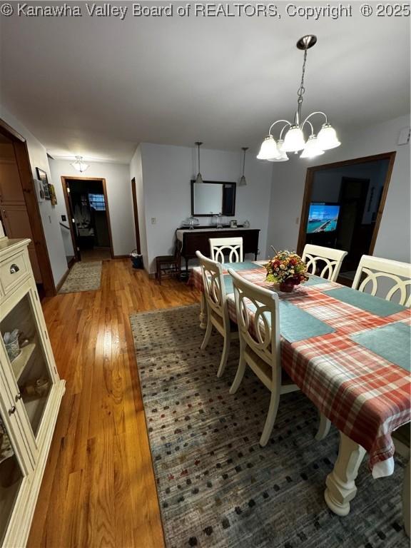 dining room with wood-type flooring and a notable chandelier