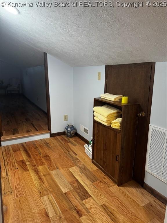 unfurnished bedroom featuring light wood-type flooring and a textured ceiling