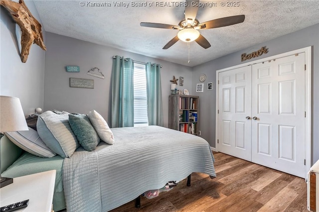 bedroom with a textured ceiling, ceiling fan, a closet, and hardwood / wood-style floors