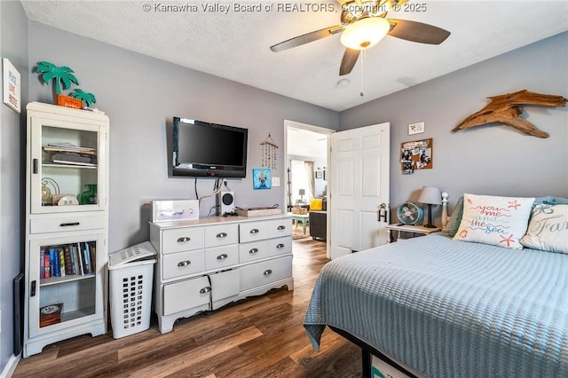 bedroom featuring ceiling fan, dark wood-type flooring, and a textured ceiling