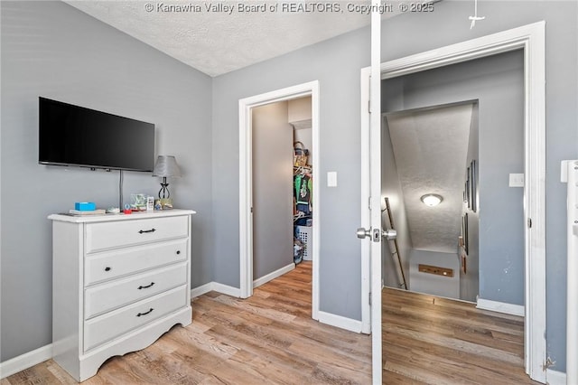 bedroom with a textured ceiling and light hardwood / wood-style floors