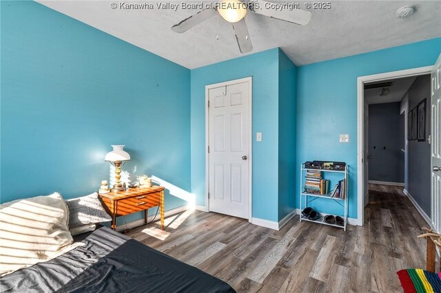 interior space featuring ceiling fan, a textured ceiling, and dark hardwood / wood-style floors