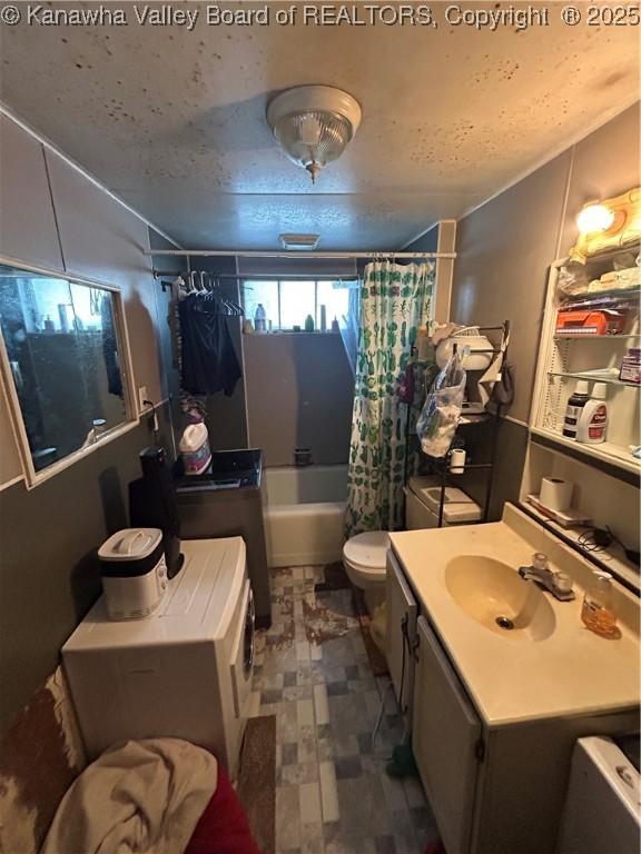 full bathroom featuring toilet, vanity, shower / tub combo with curtain, and a textured ceiling