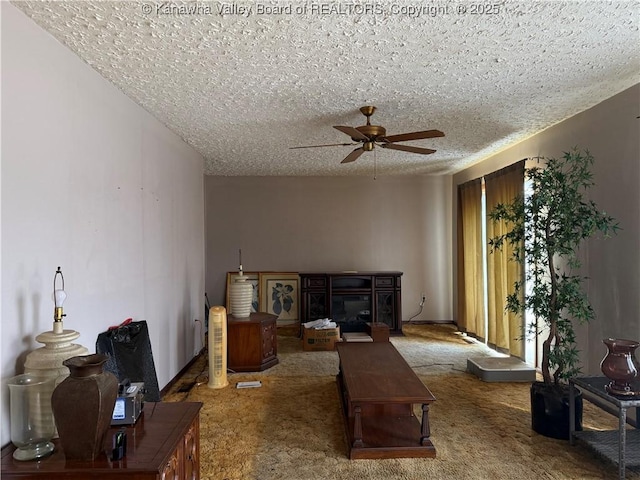 living room with a textured ceiling, carpet, a fireplace, and a ceiling fan